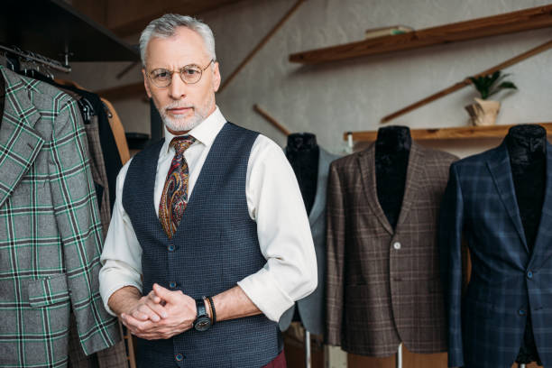 istock handsome mature tailor looking at camera in sewing workshop 972035676