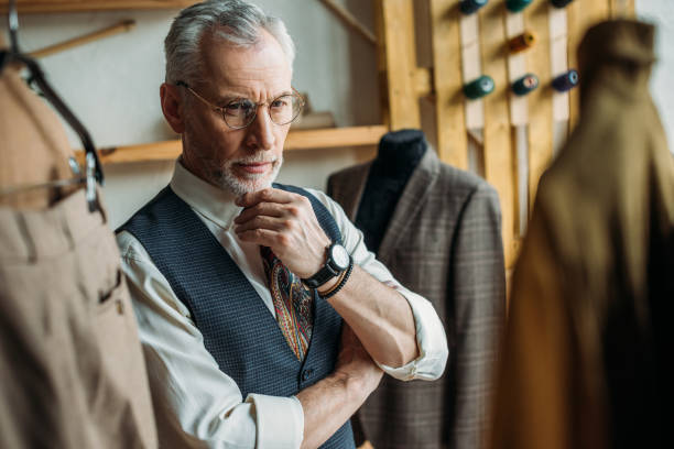 istock handsome mature man looking at jackets on hangers in store 972035818