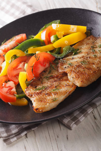 istock Grilled fish steaks and fresh vegetable salad close-up. vertical 972055394