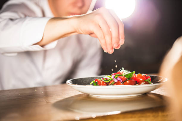 istock Closeup mid section of a chef putting salt in the kitchen 972057820