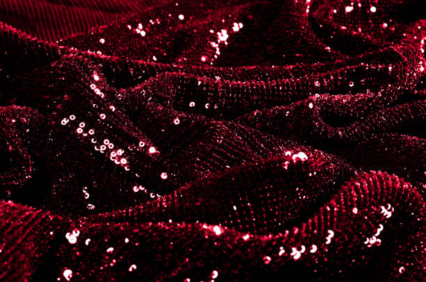 istock Texture, background, pattern, red fabric with paillettes. Look at these neon red sequins. Round neon pink sparkles glitter overlapping iridescent glitter on a clean purple grid. 972058042