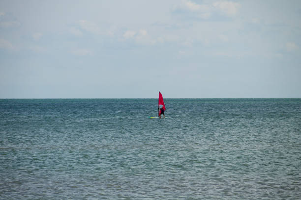 istock Windsurfing. Surfer exercising in calm sea or ocean. 972058064