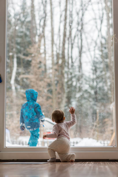 istock Little baby watching a sibling playing in snow 972077706