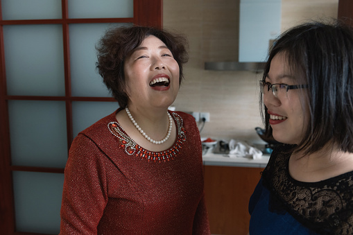 portrait of laughing chinese senior woman with her adult daughter