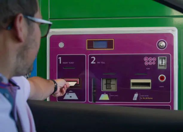 Photo of A man pays money for a toll road