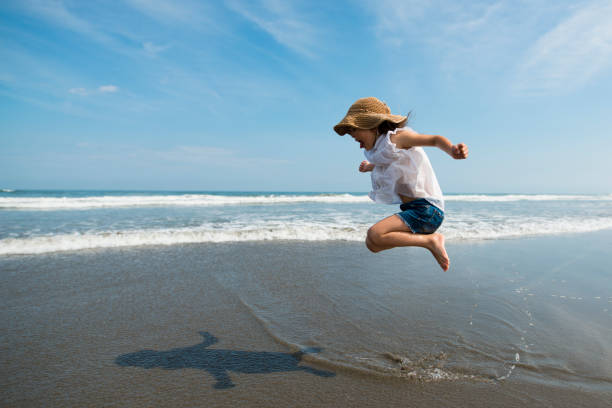 bambino che gioca in spiaggia - denim shorts foto e immagini stock