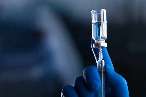 istock Medical hands holds syringe and vaccine 972105672