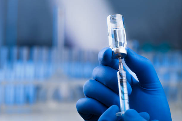 istock Medical hands holds syringe and vaccine 972105680