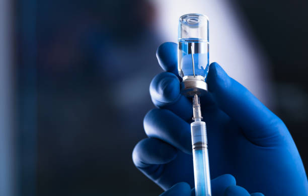 istock Medical hands holds syringe and vaccine 972105682