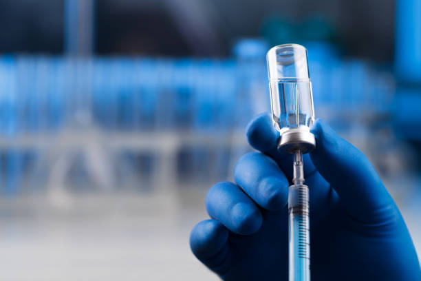 istock Medical hands holds syringe and vaccine 972105686