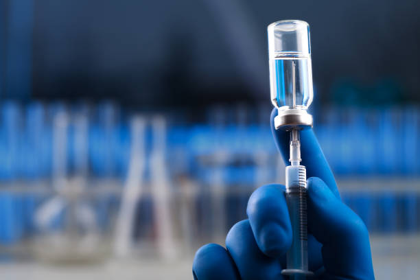 istock Medical hands holds syringe and vaccine 972105692