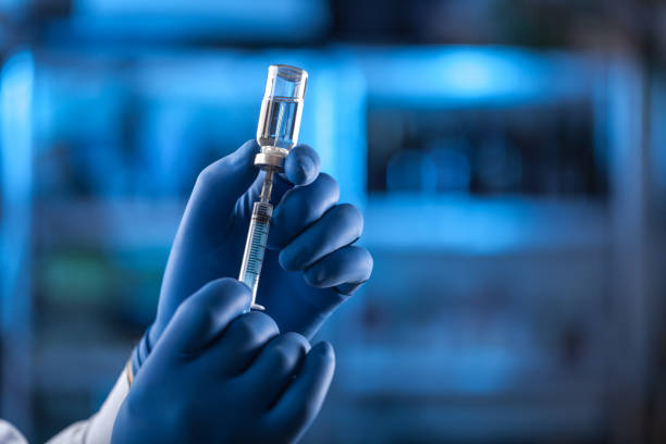 istock Medical hands holds syringe and vaccine 972105696