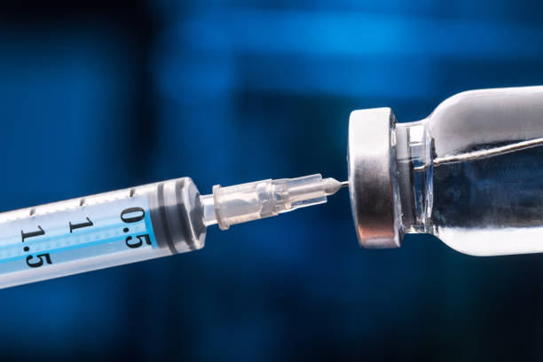 istock Medical hands holds syringe and vaccine 972105706