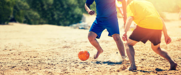 playing beach soccer - beach football imagens e fotografias de stock
