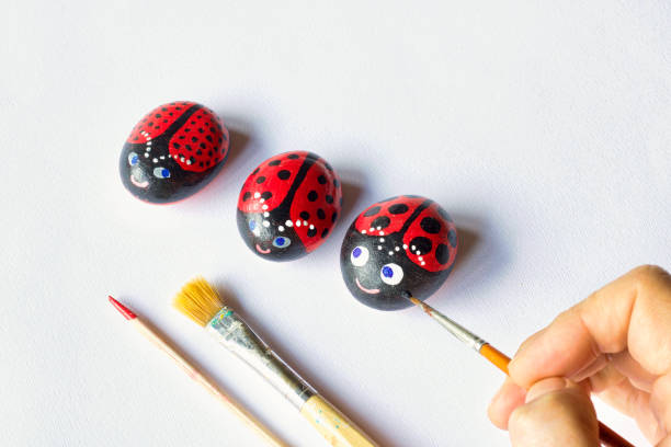 istock three painted stones as cute ladybugs on white paper background 972126106