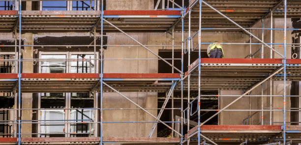 istock Facade with scaffolding and a worker working on the renovation 972134524