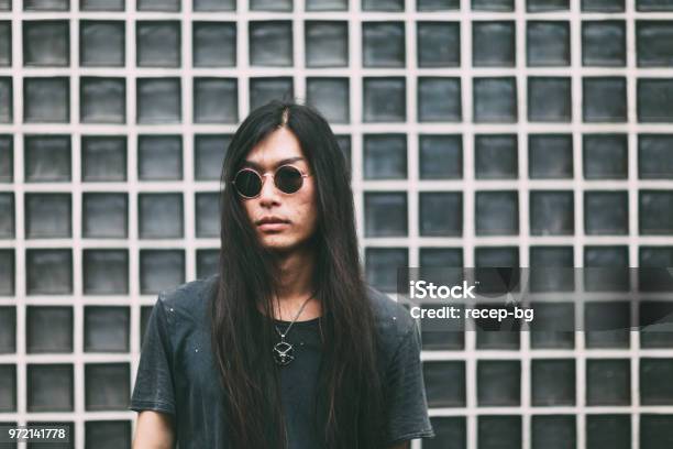 Portrait Of Handsome Japanese Man In Front Of Wall Stock Photo - Download Image Now - Men, Goth, Long Hair