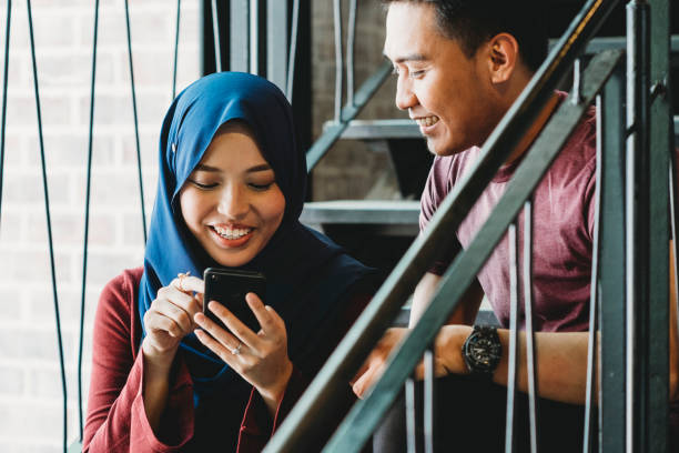 istock Multi ethnic couple sitting together with smart phone 972144338