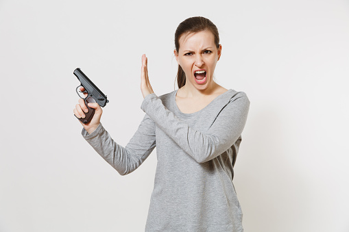 Woman with gun in hand showing stop gesture with palm isolated on white background. Girl hand no shooting symbol. Stop violence, weapons in school control, no killing people children, problem concept