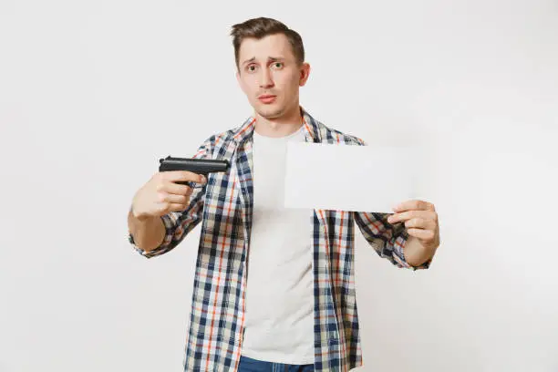 Photo of Man holding gun, blank empty sheet card, copy space isolated on white background. Male hand no shooting symbol. Stop violence, weapons in school control, no killing people children, problem concept.