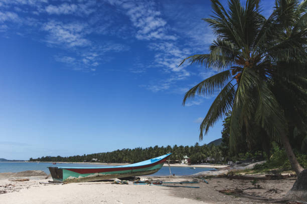 istock tranquil tropical beach with old boat on sunny day 972148418