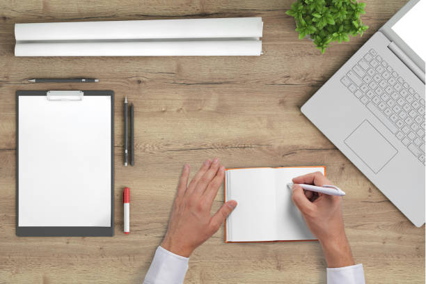 istock Business man writing on a plank notebook at an office desk 972150884