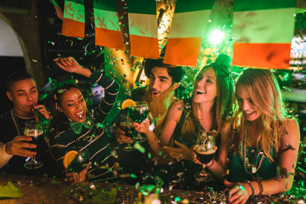 amigos de fiesta con bebidas y confeti en el día de san patricio - irish culture fotografías e imágenes de stock