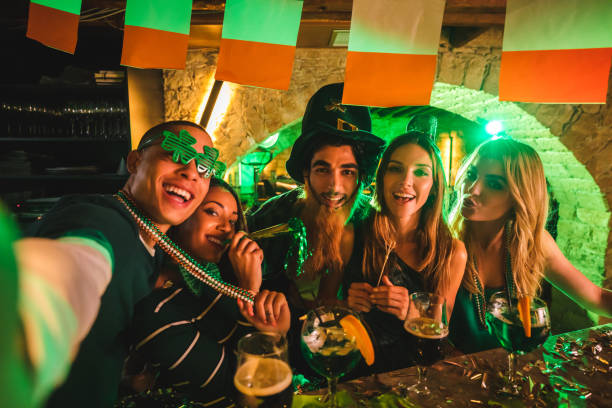 istock Happy multi-ethnic friends taking selfies at Saint Patrick's day party 972155678