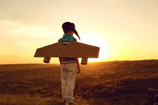 Photo of Teenager with toy airplane on nature at sunset
