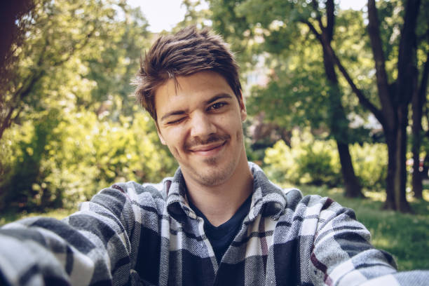 istock attractive and handsome young man taking a selfie with a tablet, making a silly spontaneous face. 972176998
