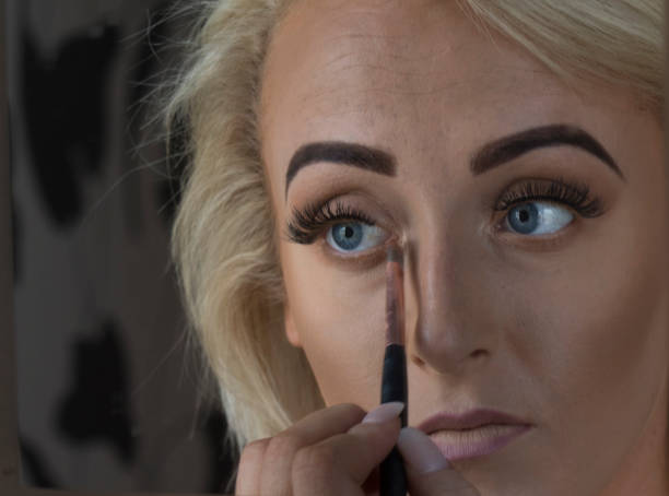 istock Applying Make Up in Bathroom Mirror, Beautiful Blond Young Woman 972179542