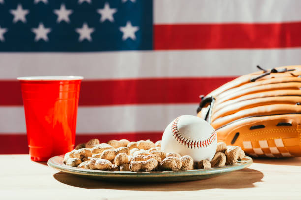 vue rapprochée de la balle et gant, arachides et rouge coupe en plastique de baseball - baseball baseballs peanut american culture photos et images de collection