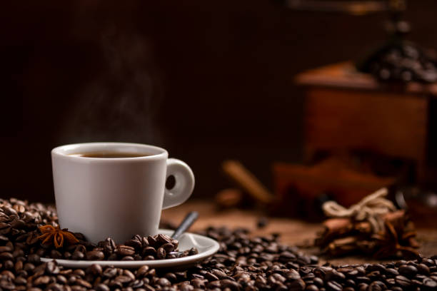 istock Cup of coffee with coffee beans and grinder on wooden table 972185088