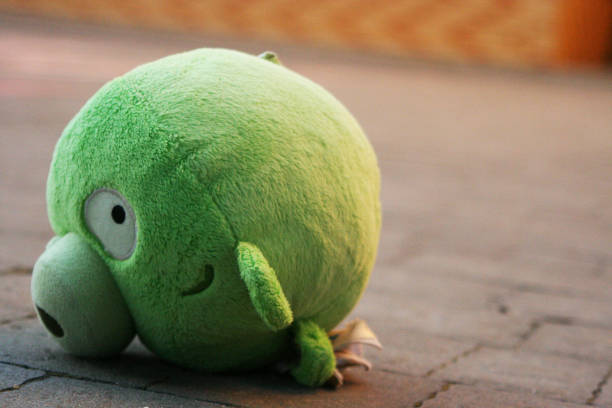 A toy pig upside down on the ground