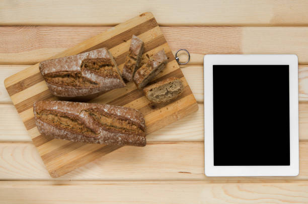 istock Sliced baked bread on cutting board with digital tablet 972206174