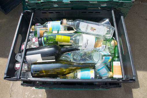 Marazion, Cornwall, UK - May 18, 2018: A tray holding glass and bottles ready for recycling in a small industrial yard.