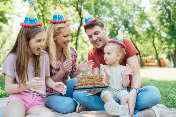 istock Happy family holding birthday cake and clapping their hands 972240854