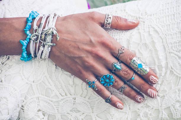 hand with lot of boho style jewerly closeup of young woman hand with lot of boho style jewelry, rings and bracelets outdoor summer day bijou personal accessory stock pictures, royalty-free photos & images