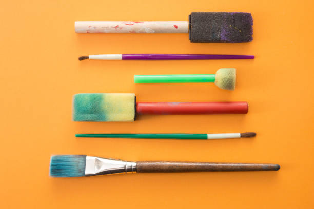 istock Children's Paint Brushes on a Orange Background 972245886