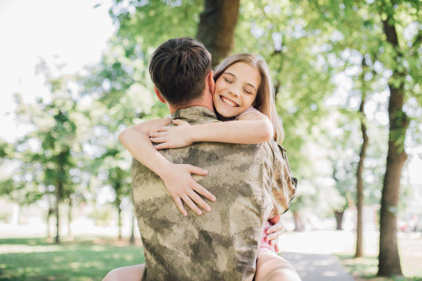 istock Soldier holding daughter in his arms 972252648