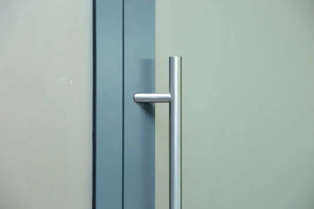 Photo of Door joinery made of aluminum frame and with a glass filling with a sticker that makes the rail opaque and gives a white milky color.