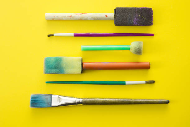 istock Children's Paint Brushes on a Yellow Background 972253068