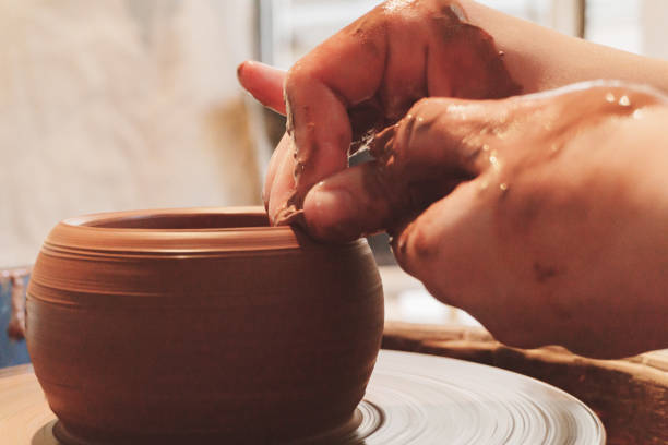 istock Making dirty hands of raw clay ware in a pottery workshop 972257620