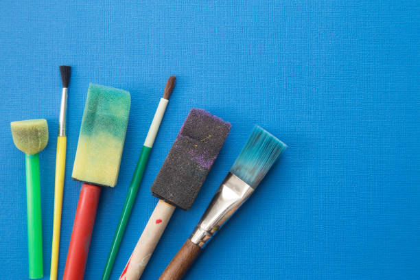 istock Children's Paint Brushes on a Blue Background 972298336