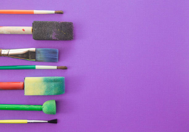 istock Children's Paint Brushes on a Purple Background 972301844