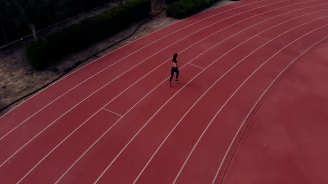 Aerial view of athletic woman running on running track