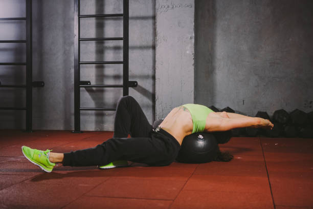 istock sportswoman uses a foam roller massager for stretching 972310618