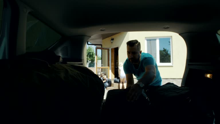 Family packing bags in car trunk