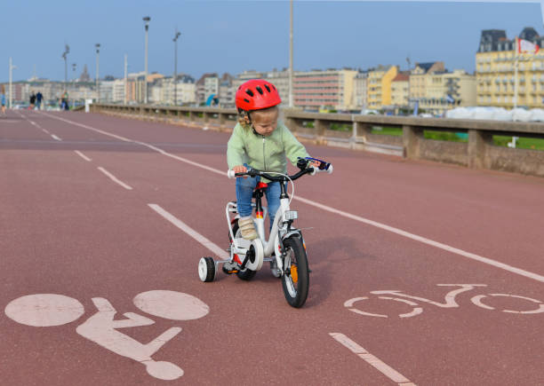 istock Girl in helmet learns riding a four-wheeled bicycle 972325850