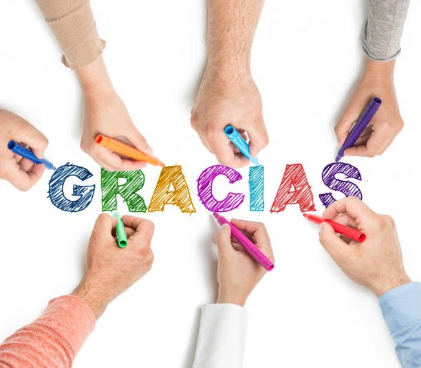 Seven different arms and hands of people hold markers while contributing to a colorful sketch of the phrase \